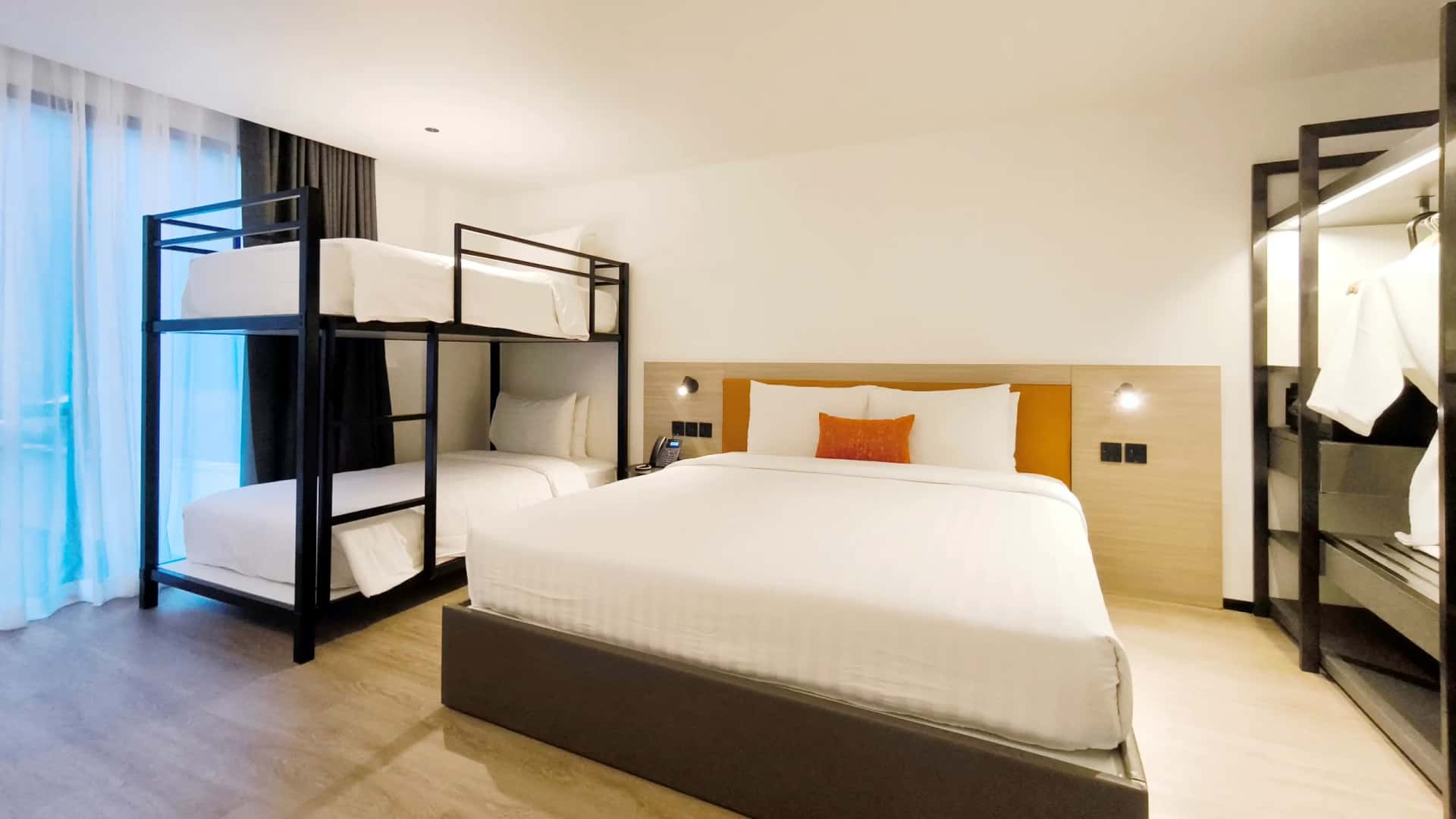 Bedroom with a bed, a bunk bed, and an open wardrobe.