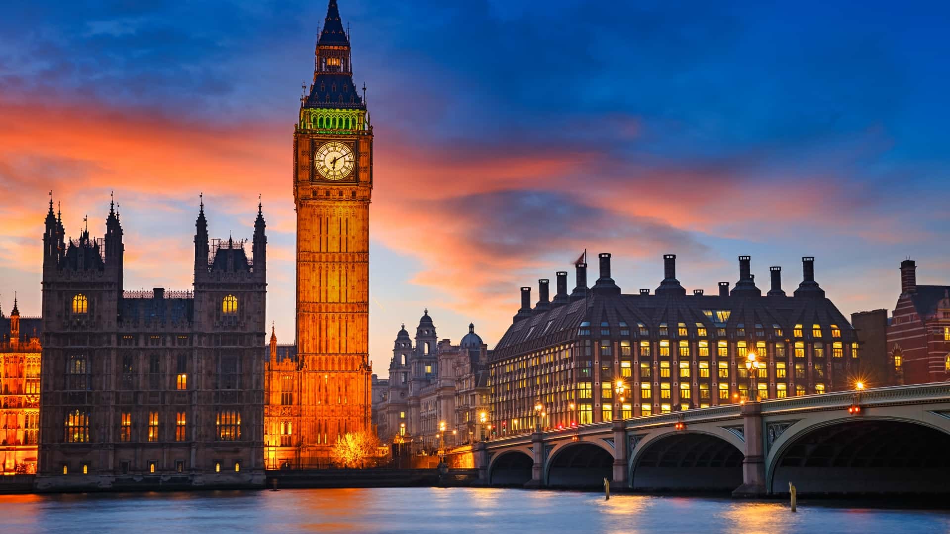 Big Ben and the Palace of Westminster at sunset with reflections on the River Thames