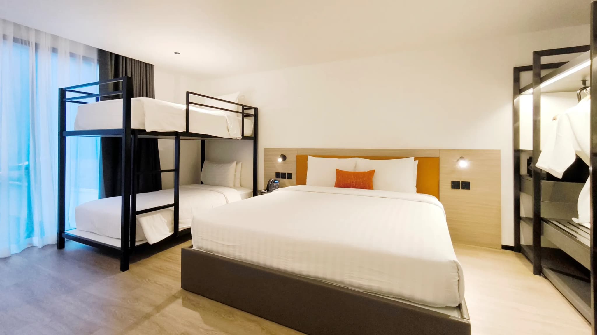 Bedroom with a bed, a bunk bed, and an open wardrobe.